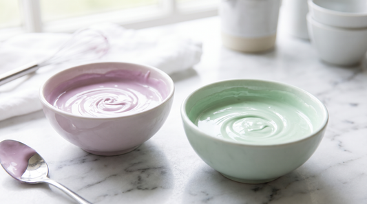 Melted white chocolate tinted soft lilac and mint in two small bowls