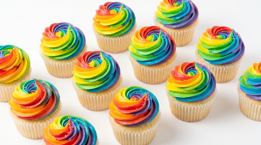 Cupcakes topped with a vivid multi-color rainbow frosting swirl
