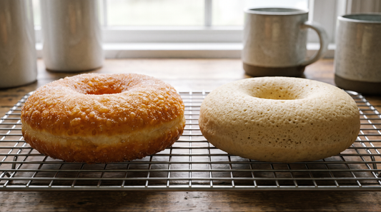 A fried donut and a baked donut side by side on a wire rack showing texture difference