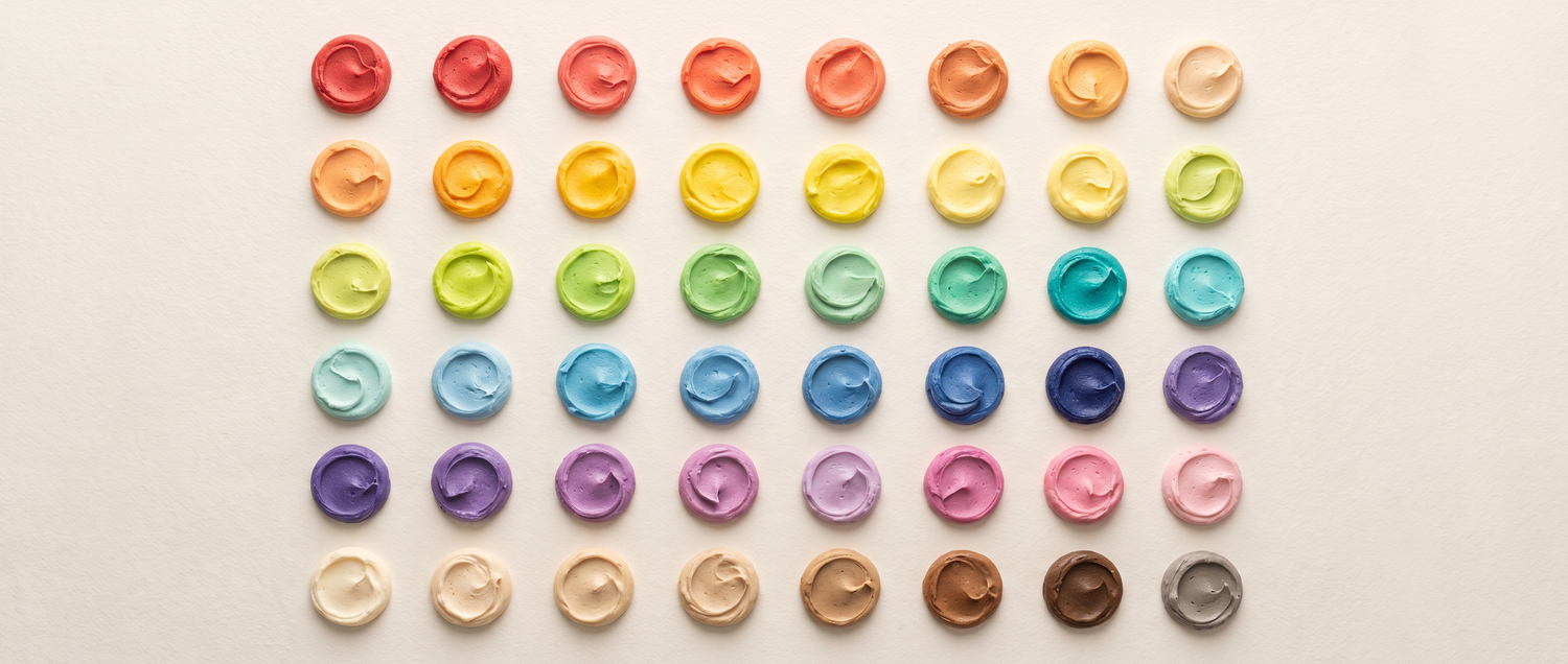 A precise grid of forty-eight buttercream colour swatches arranged as a full spectrum on bone-white paper, in the style of a pigment specimen chart